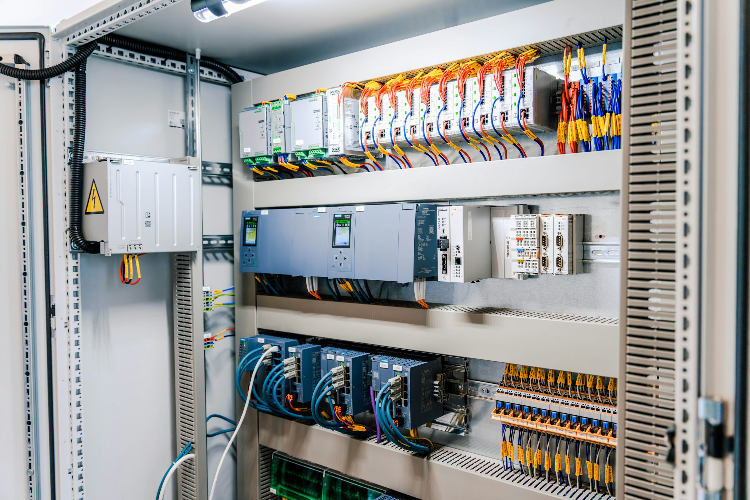 Open control panel with breakers, modules and labelled wiring